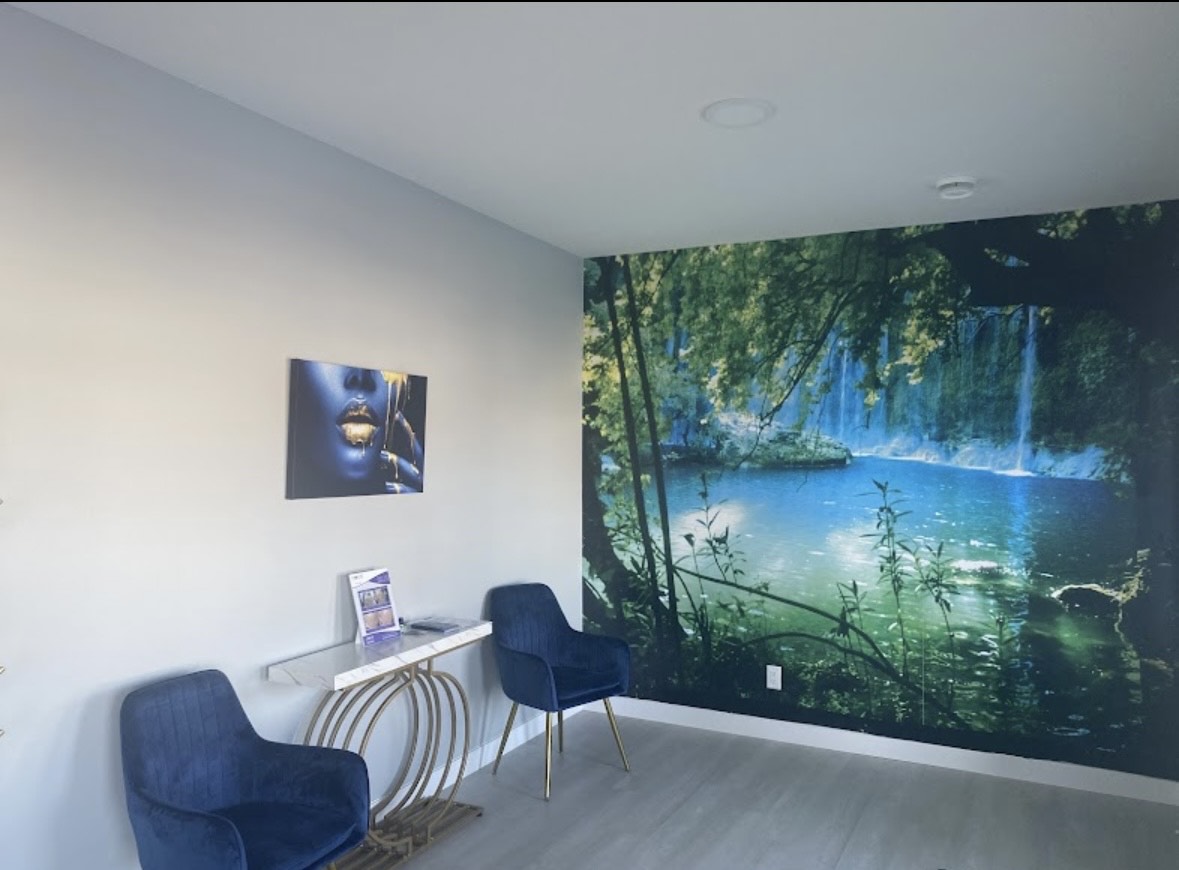 Modern room with blue chairs, art, and large waterfall landscape mural
